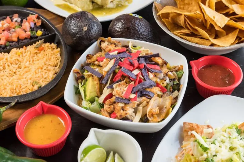 Platter of tacos with rice, guacamole and salsas at Tomatillos