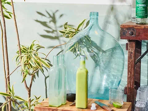 House agua fresca, agave spirits and a cutting board on the bar prep station at Güero