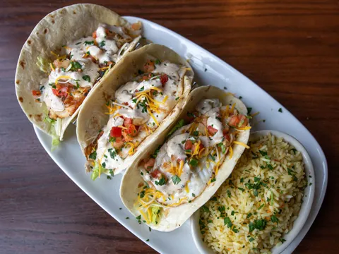 Blackened mahi fish tacos topped with pico de gallo and chipotle ranch, served with chesapeake rice at Nick's Fish House in Baltimore
