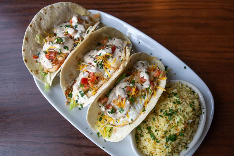 Blackened mahi fish tacos topped with pico de gallo and chipotle ranch, served with chesapeake rice at Nick's Fish House in Baltimore