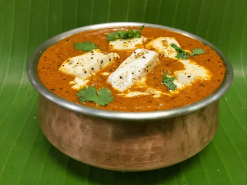 Paneer butter masala in a copper bowl on a banana leaf at Udipi Cafe