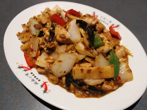 Kung pao chicken with red and green peppers and onions on a Henry's Hunan branded plate