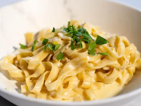 Fettuccine in a creamy sauce garnished with parsley in a white bowl at La Dolce Vita in Cleveland's Little Italy