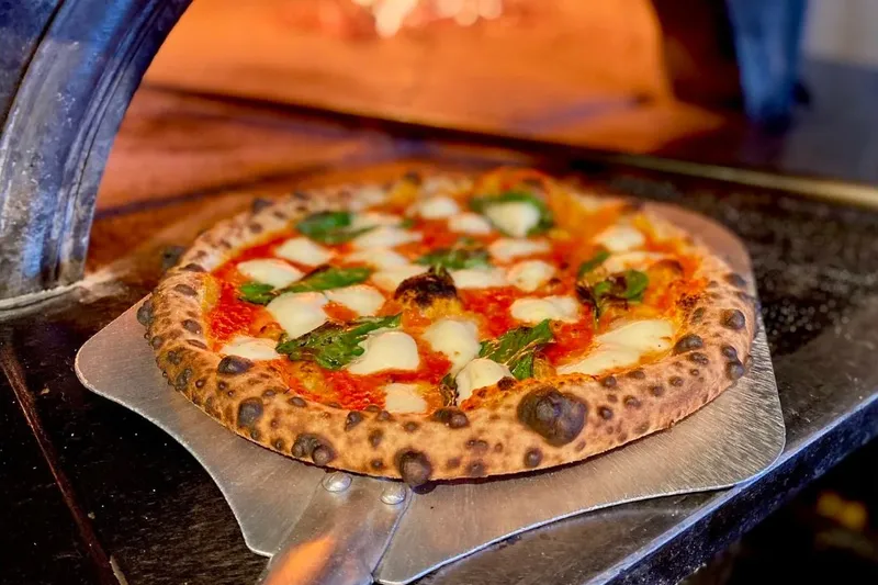 Margherita pizza at the mouth of Bar del Corso's wood-fired oven