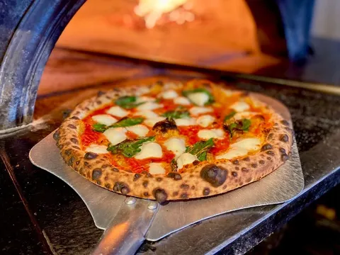 Margherita pizza at the mouth of Bar del Corso's wood-fired oven
