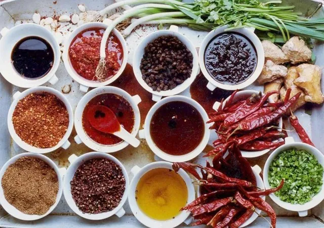 Overhead tray of Sichuan seasonings at Q by Peter Chang — chili oils, chili pastes, dried chilies, Sichuan peppercorns, ginger and scallions in small white bowls