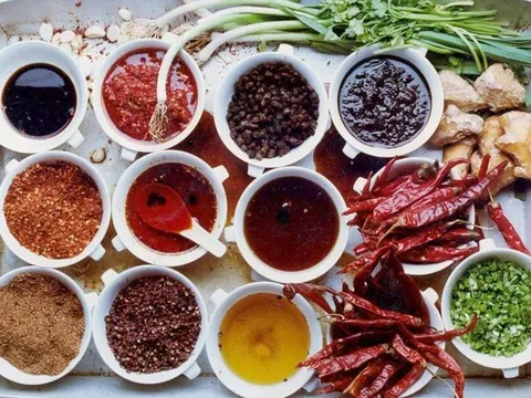 Overhead tray of Sichuan seasonings at Q by Peter Chang — chili oils, chili pastes, dried chilies, Sichuan peppercorns, ginger and scallions in small white bowls