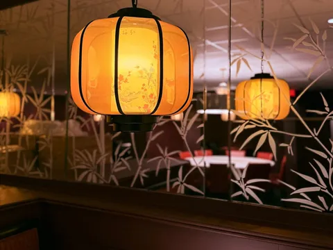 Glowing painted lanterns reflected in mirrored bamboo-patterned walls inside Hunan Lion in Columbus