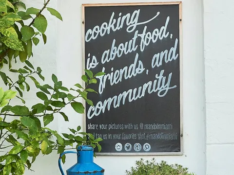 Mandolin Aegean Bistro wall sign about food, friends, and community