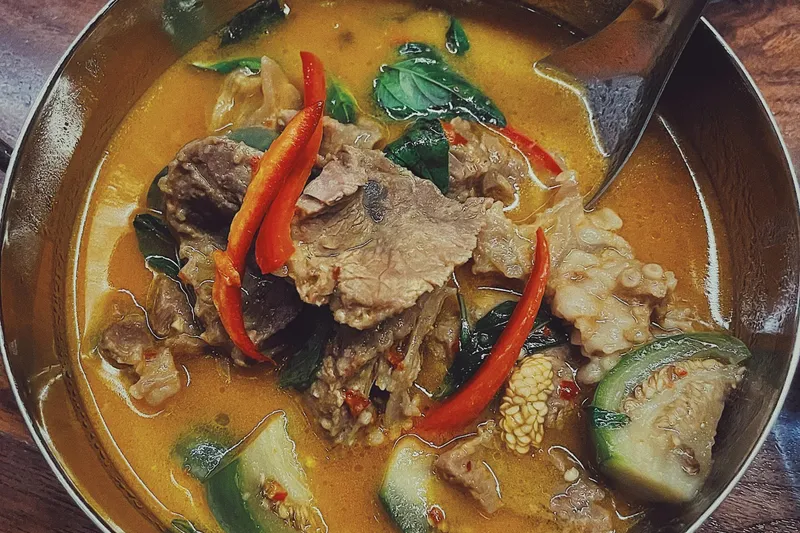 Bowl of southern-style Thai red curry with beef, Thai basil, red chilies and vegetables at Lom Wong in Phoenix