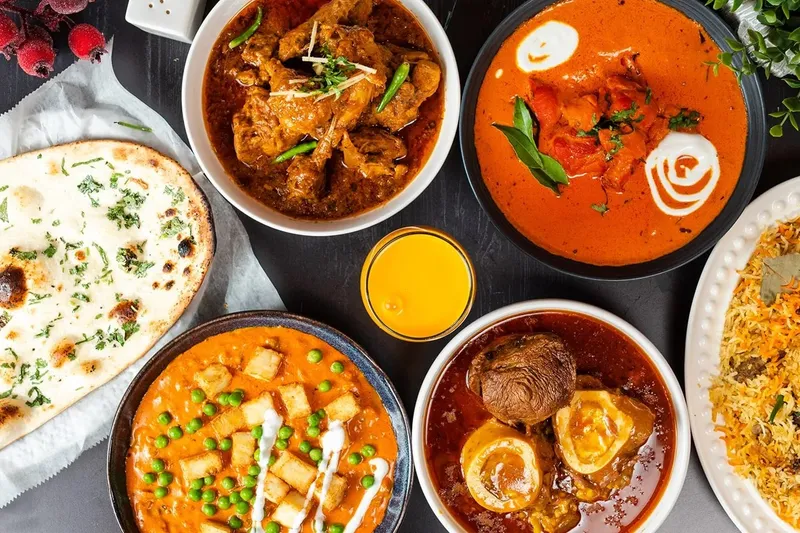 A spread of naan, curries, rice, and grilled dishes from Sabri Nihari.