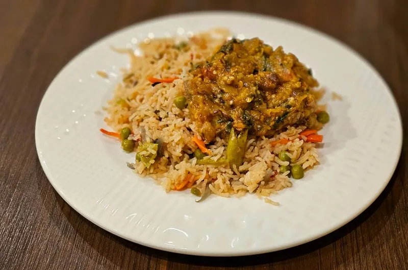 Plate of vegetable fried rice topped with a spiced curry at Jay Hind Indian Cuisine in Chandler.