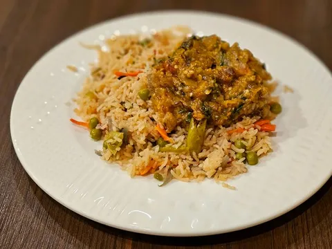 Plate of vegetable fried rice topped with a spiced curry at Jay Hind Indian Cuisine in Chandler.