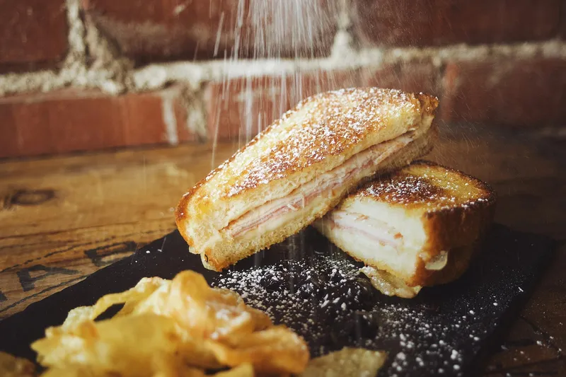Grilled Monte Cristo sandwich dusted with powdered sugar at The Wheel Barrel