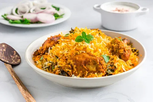 Namaste Flavours special chicken biryani served with raita, sliced onions and mint