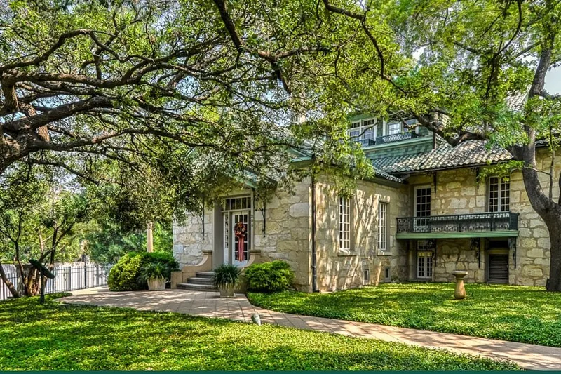 The Guenther House's historic limestone homestead surrounded by oak trees
