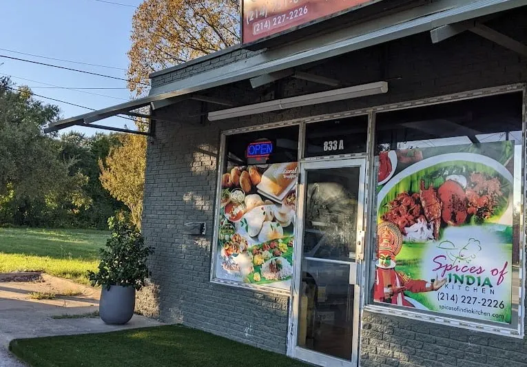Storefront of Spices of India Kitchen on E Shady Grove Rd in Irving, with an OPEN sign and Kerala food window decals