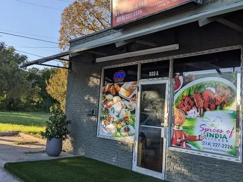 Storefront of Spices of India Kitchen on E Shady Grove Rd in Irving, with an OPEN sign and Kerala food window decals