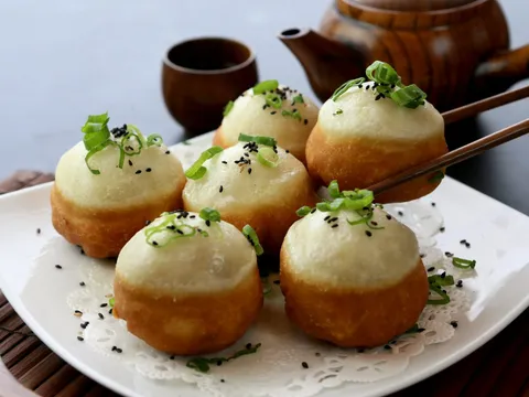 Shanghai-style pan-fried pork buns (sheng jian bao) topped with scallions and sesame seeds at Dumpling Kitchen