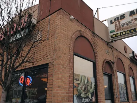 The brick corner storefront of Los Altos Taqueria & Restaurant at 7056 West Vernor Highway, with its painted overhead sign and neon Open sign