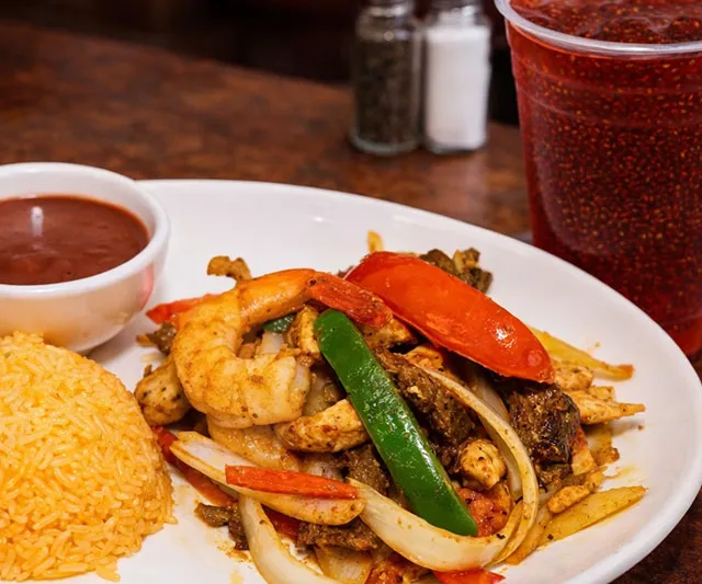 Mixed fajita plate of chicken, beef and shrimp with yellow rice and refried beans at El Rinconcito Café in Washington, DC
