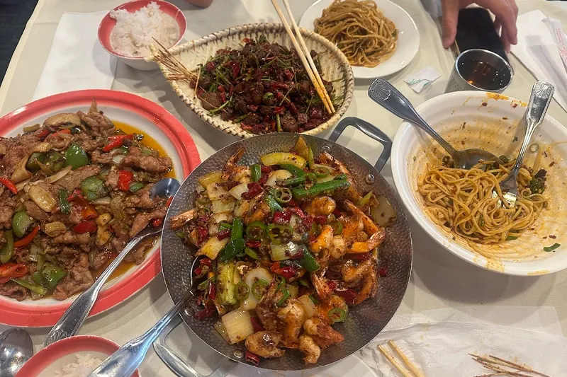 Table spread of Sichuan dishes and noodles at Chengdu Taste