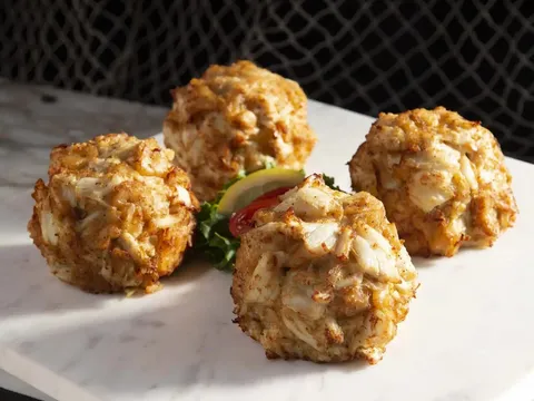 Four jumbo lump crab cakes on a marble slab at Faidley's Seafood