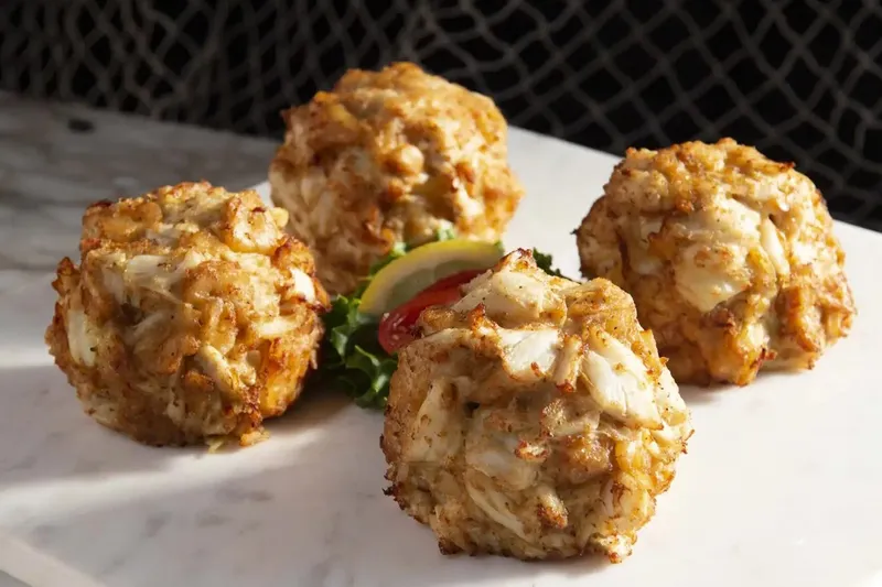 Four jumbo lump crab cakes on a marble slab at Faidley's Seafood