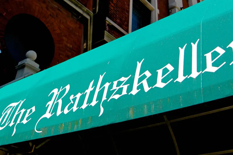Green awning reading "The Rathskeller" over the restaurant's entrance