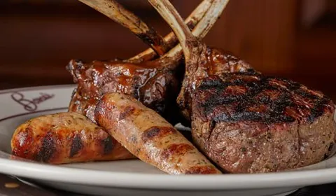 Plate of grilled sausages, lamb chops and filet at Bones Restaurant