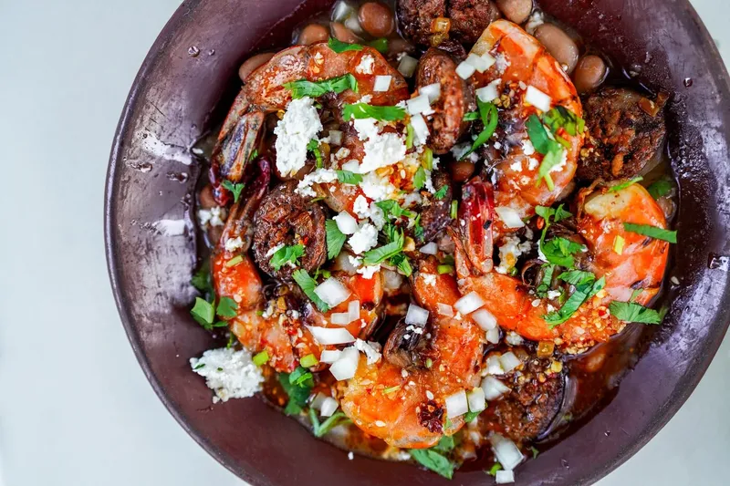 Wood-fired Sonoran dish with roasted vegetables and fresh garnishes at Bacanora