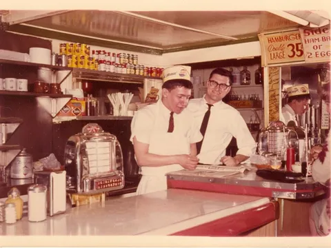 Vintage photo of countermen behind the counter at Sam's No. 3, with a jukebox in the foreground