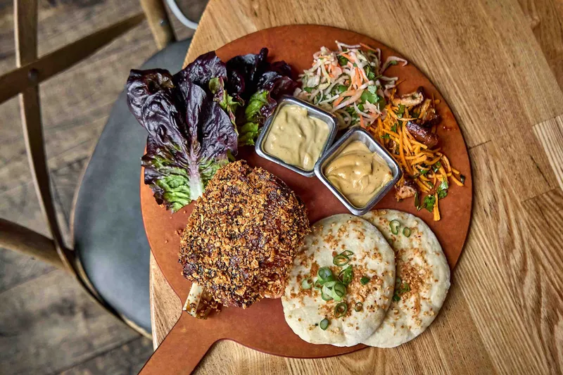 Crispy pork shank with lettuce cups and flatbread at Girl & the Goat