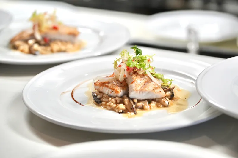 A plated seafood dish over risotto from Andiamo in Banca in South San Francisco.