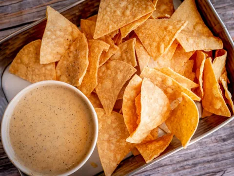 Basket of tortilla chips with a cup of queso at HiFi Burritos