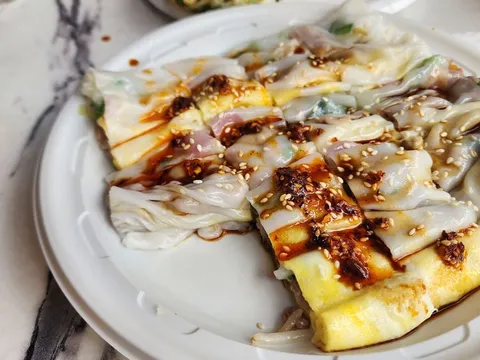 Steamed rice rolls (cheung fun) drizzled with sweet soy and chili oil and topped with sesame seeds at Joe's Steam Rice Roll, Flushing