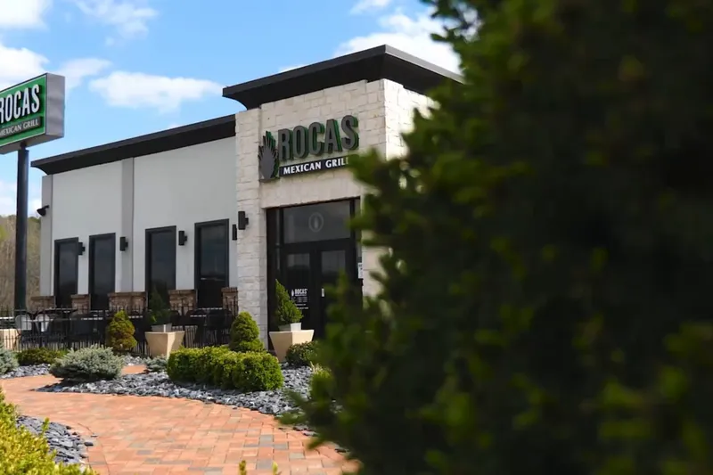 Exterior of Rocas Mexican Grill with landscaped beds along the walkway