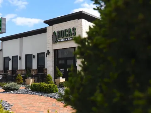 Exterior of Rocas Mexican Grill with landscaped beds along the walkway