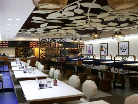 Dining room with blue booths and a leaf-patterned ceiling at Chi Cafe in Chinatown