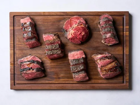 A walnut carving board topped with an assortment of sliced cooked steaks at Bardea Steak in Wilmington