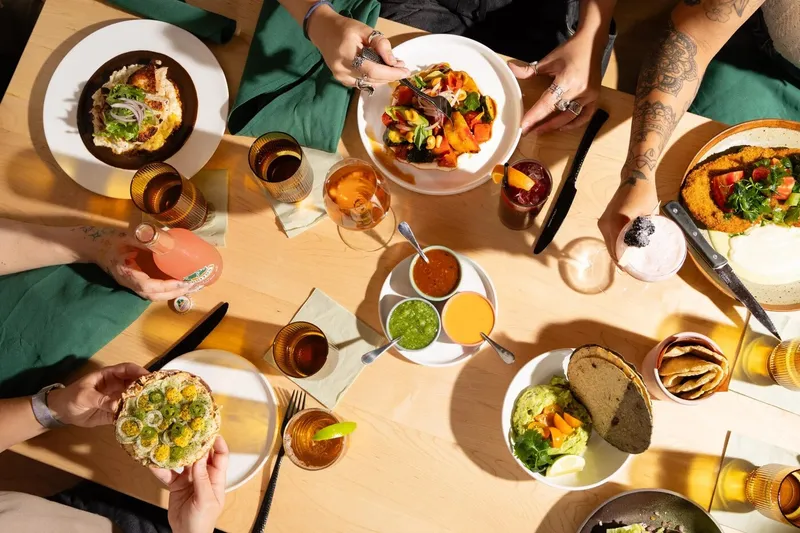 A table spread of tacos, tostadas, salsas and drinks at Maíz de la Vida
