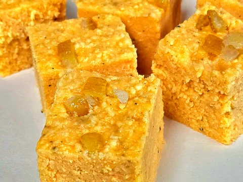 Squares of orange barfi topped with candied fruit, an Indian sweet from Surati Farsan Mart