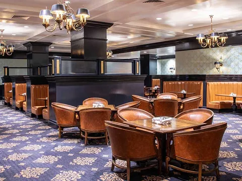 Dining room with leather chairs and chandeliers at Antlers Grille