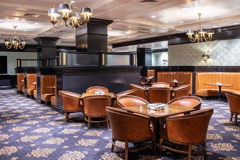 Dining room with leather chairs and chandeliers at Antlers Grille