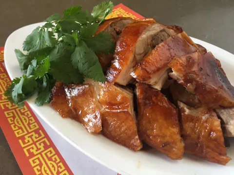 Plate of sliced Cantonese roast duck with crispy skin and fresh cilantro at First Chinese BBQ in Richardson