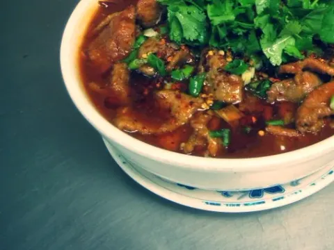 Sichuanese Boiled Beef, a spicy chili-oil stew topped with cilantro, served in a bowl at Sichuanese Cuisine in Seattle