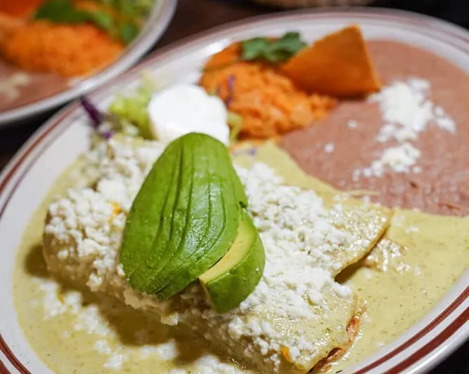 Enchiladas suizas topped with avocado and cotija cheese at Lindo Michoacan