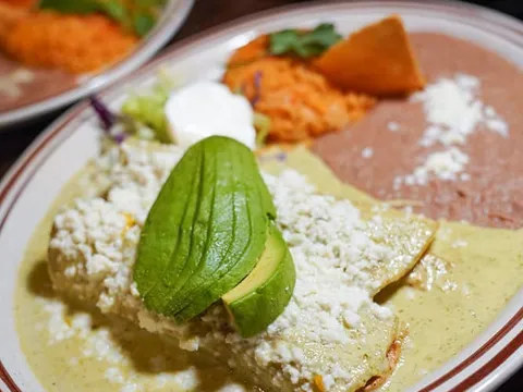 Enchiladas suizas topped with avocado and cotija cheese at Lindo Michoacan