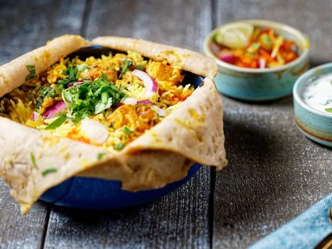 Dum biryani sealed with roti, served with raita and salan at Nirmanz Food Boutique