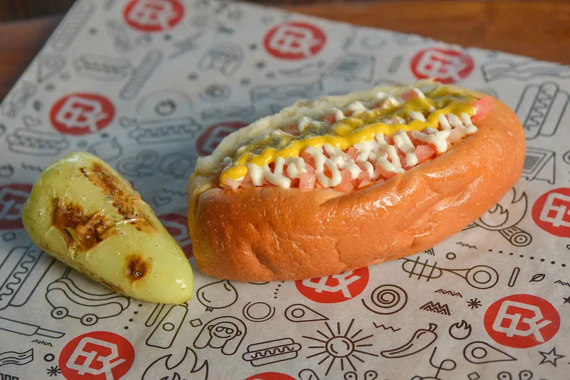 BK's award-winning Sonoran hot dog wrapped in bacon and topped with beans, onions, tomato, mayo and mustard, with a grilled yellow pepper, on BK-logo paper